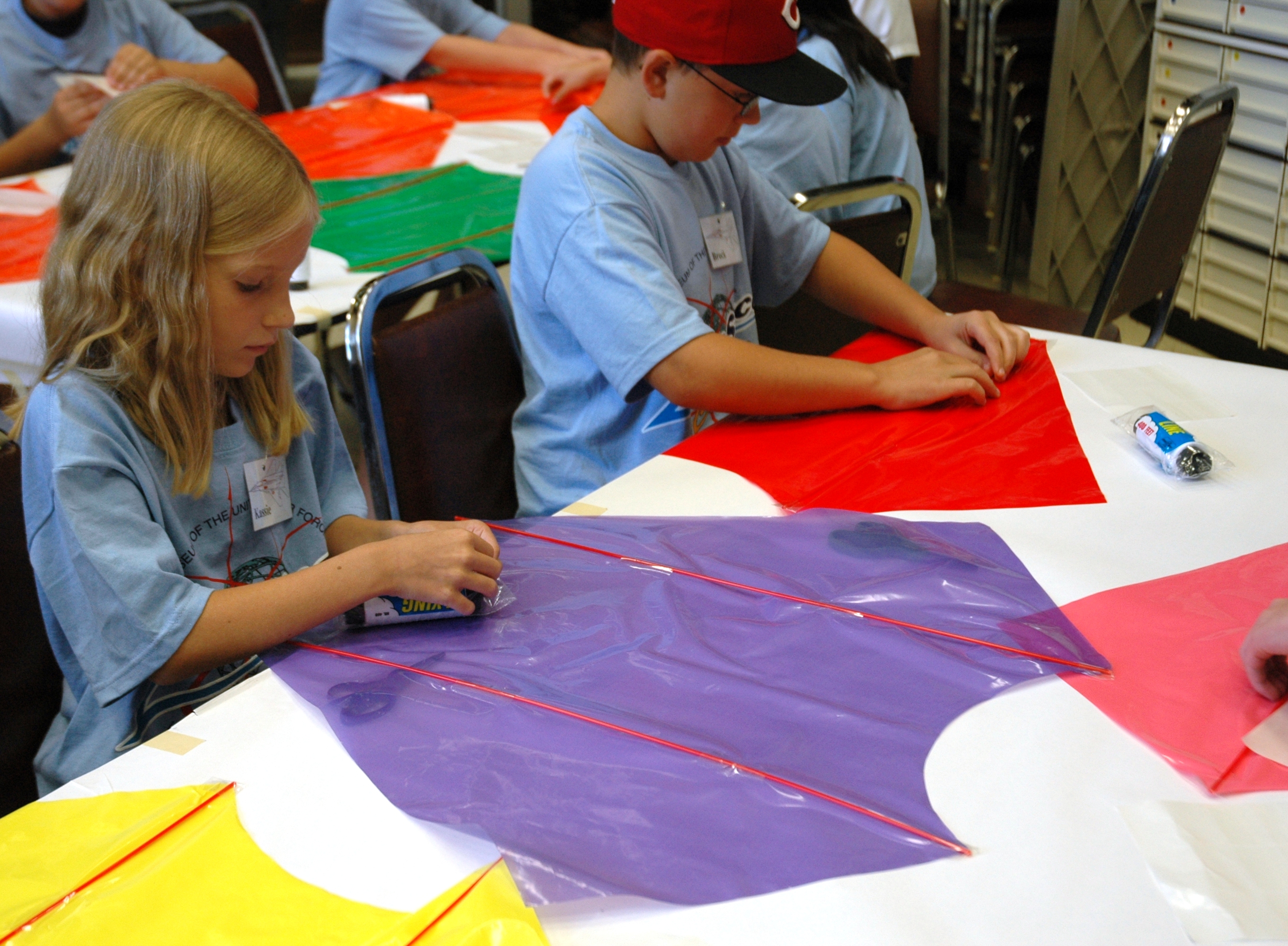 Students seated at table designing a sled kite.